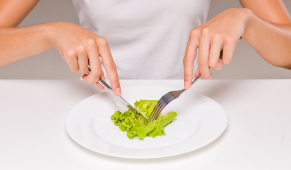 Pessoa cortando uma folha de alface